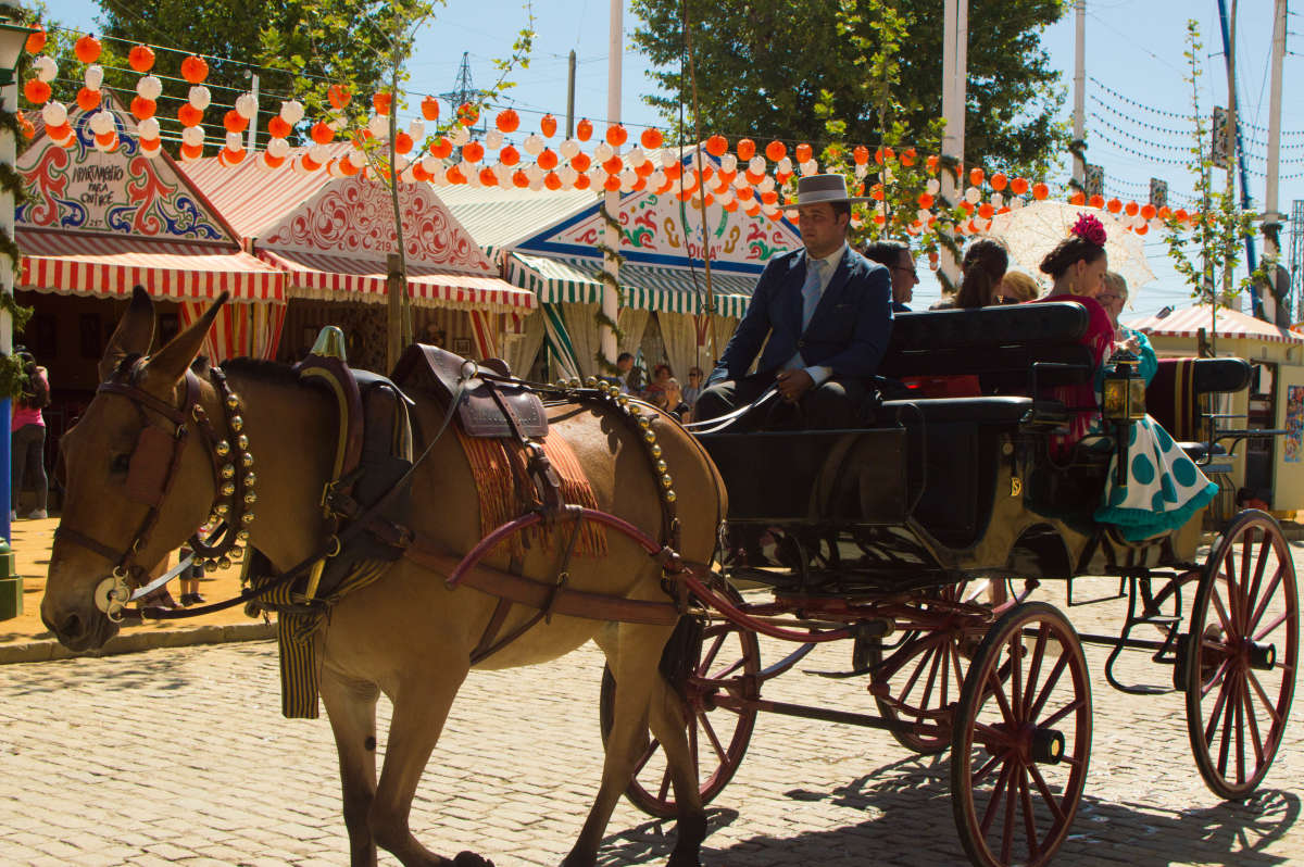 People taking a ride in a horse car dressed with regional suits