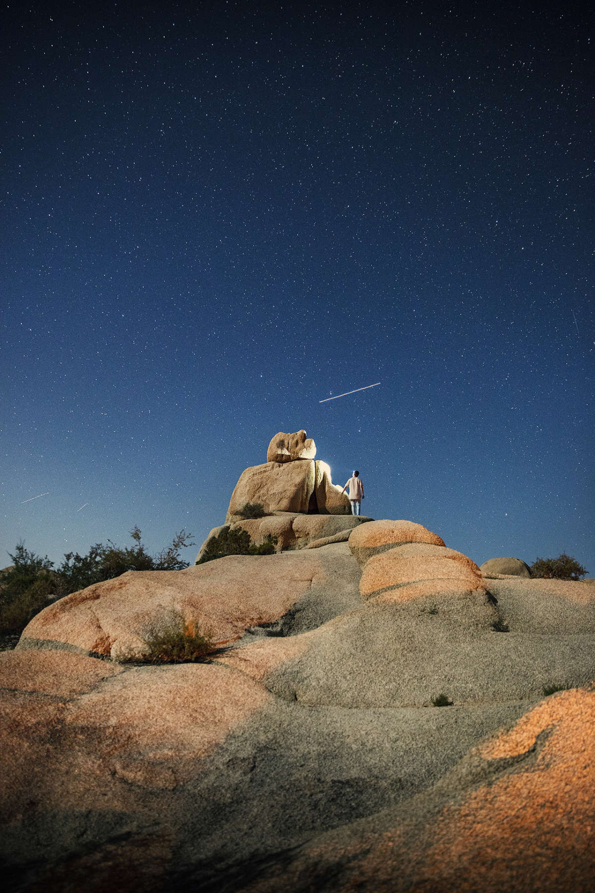 This is a single photo with the moon lighting up the landscape, my headtorch shining on the rock, and a plane trailing overhead.