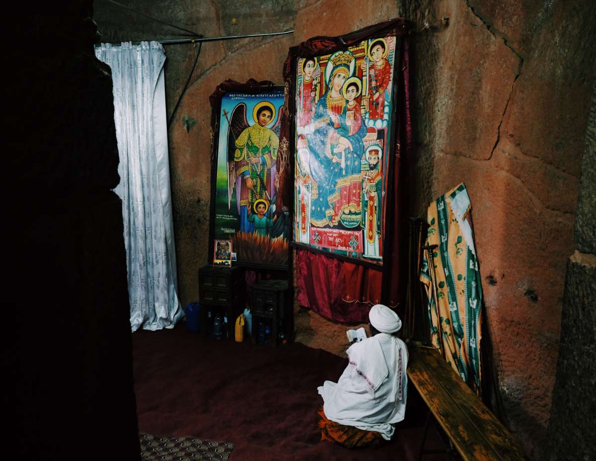 A priest prays in one of the rock-hewn churches