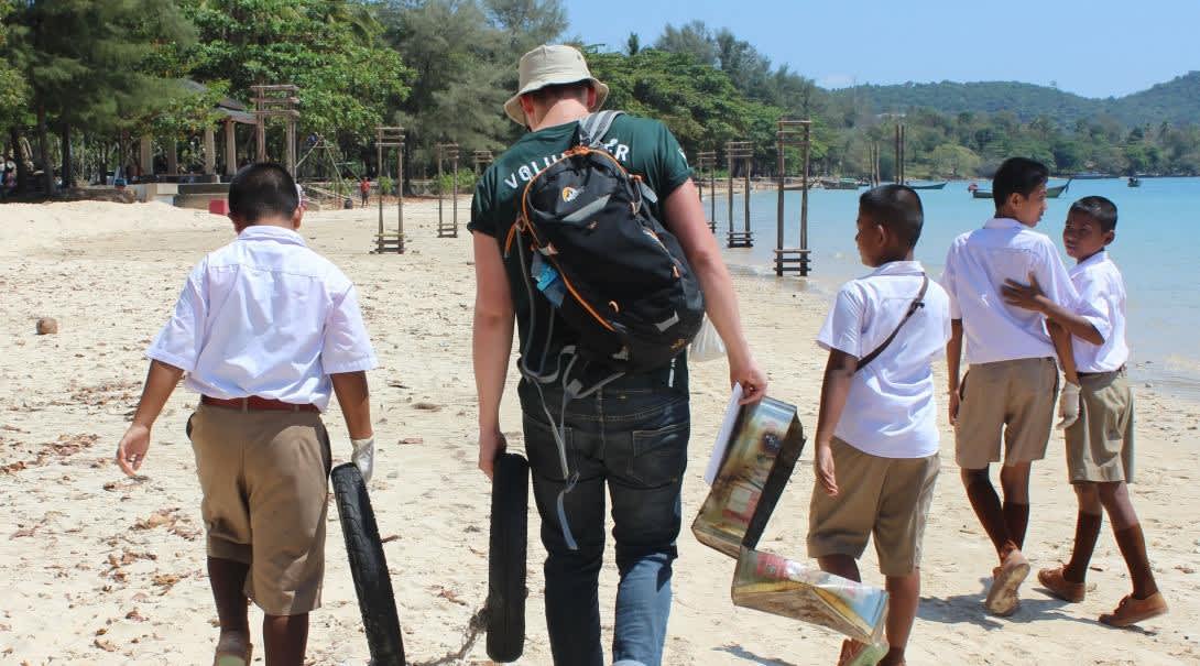 Conservation Volunteer doing a beach clean up with local students on a Community Outreach Day. 