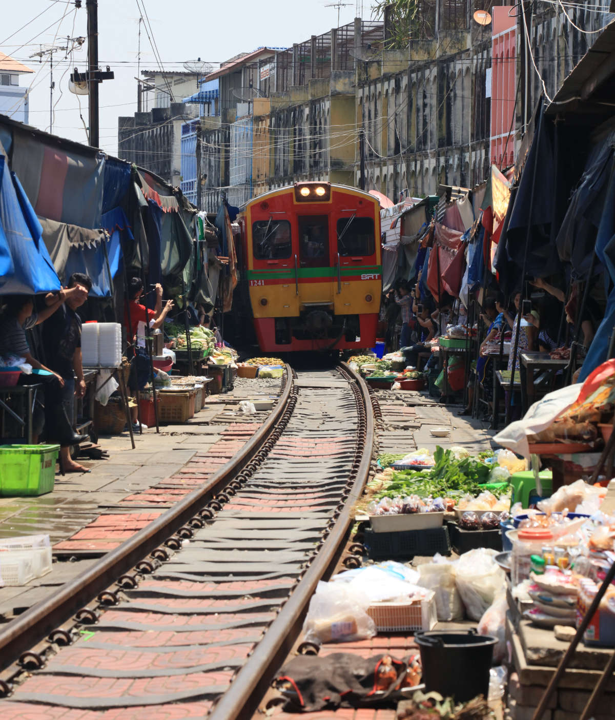 Vendors pulling the awnings back for the train to pass