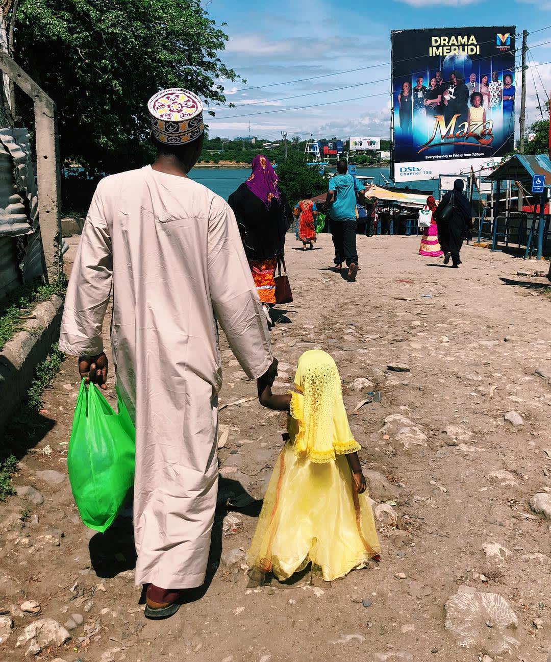 A father and daughter walks towards the Likoni Ferry