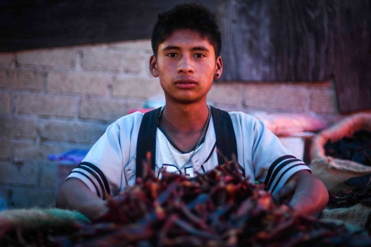 Boy selling chile in the supply center.