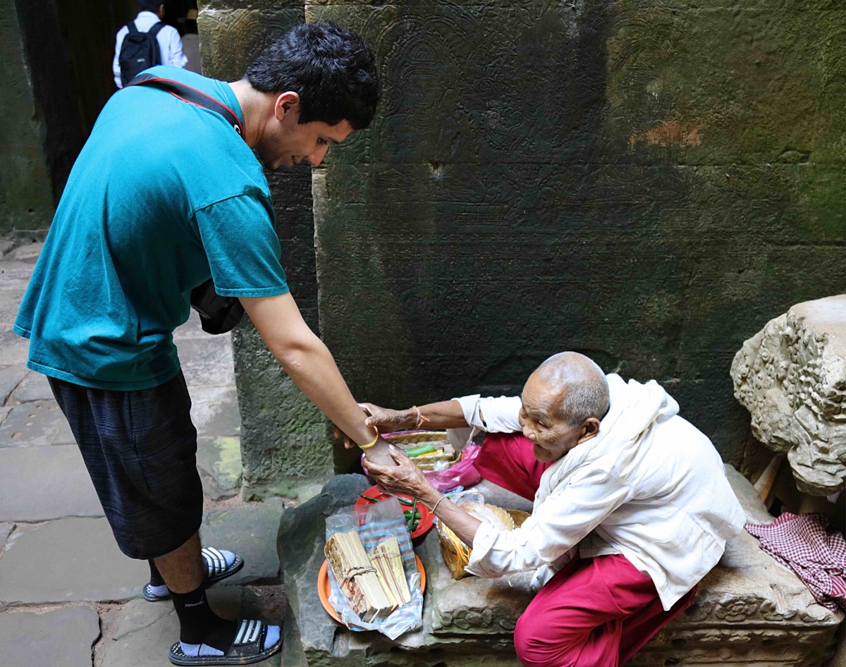 Son getting blessed from a Chi Phram for a small donation