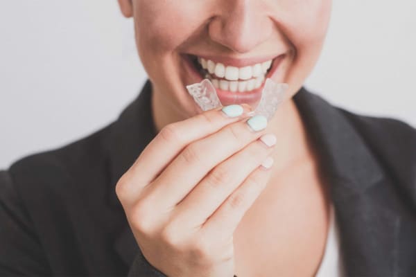 Adult inserting a retainer in mouth