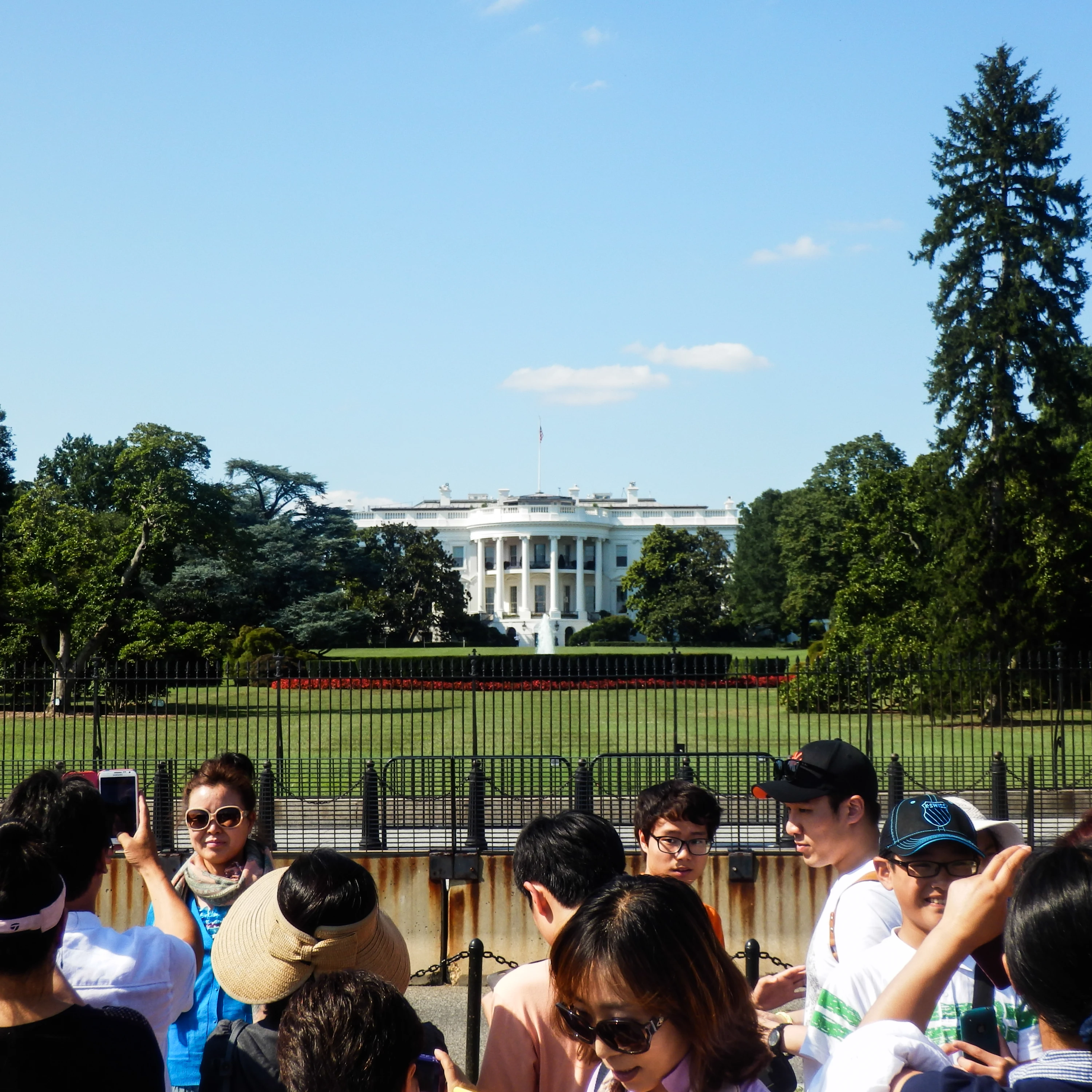 a group of East Asian people in front of the White House