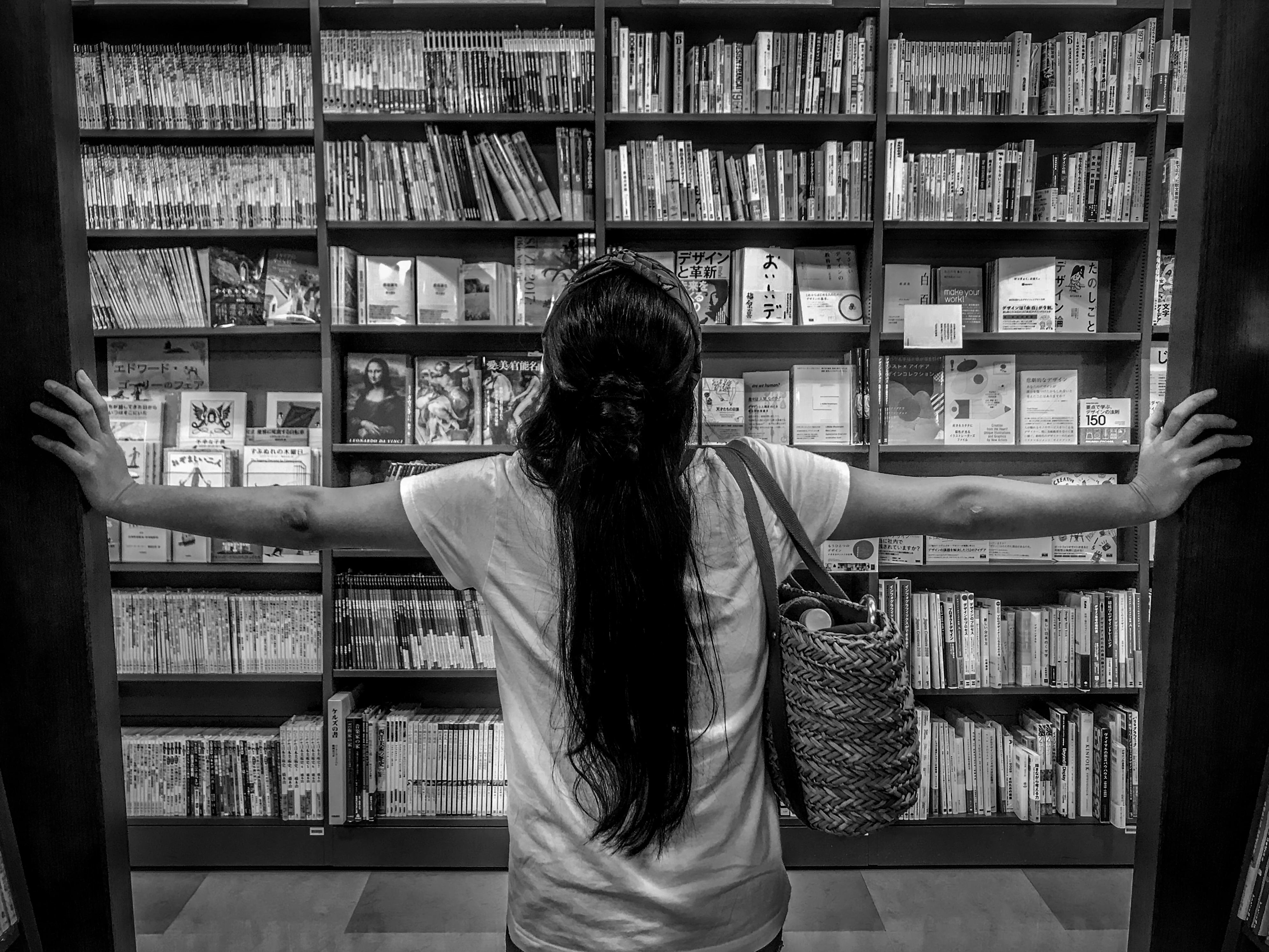 a woman standing gloriously in front of a bookcase