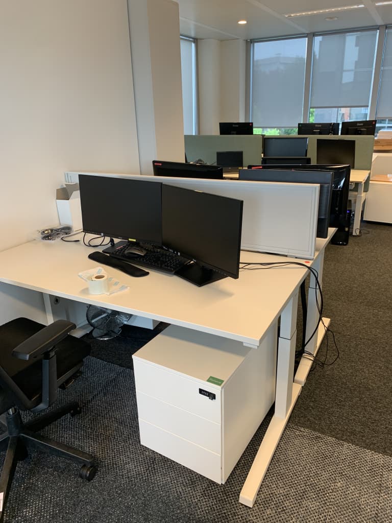 Bureau duo blanc de Steelcase avec cloison en acier blanc, gestion centrale des câbles et hauteur réglable product image 1