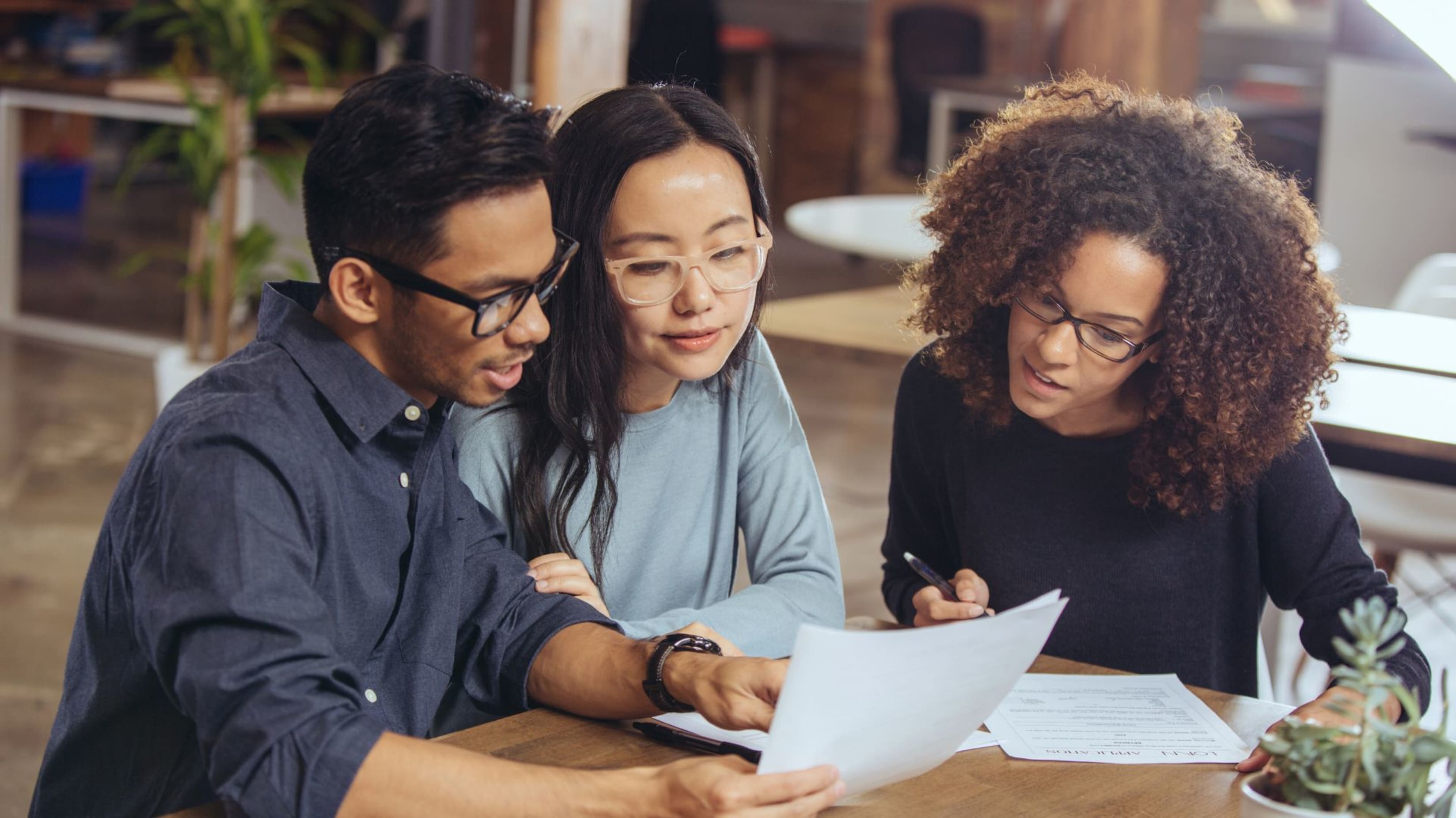 Two women and a men in the living room talking about The Costs of Homeownership