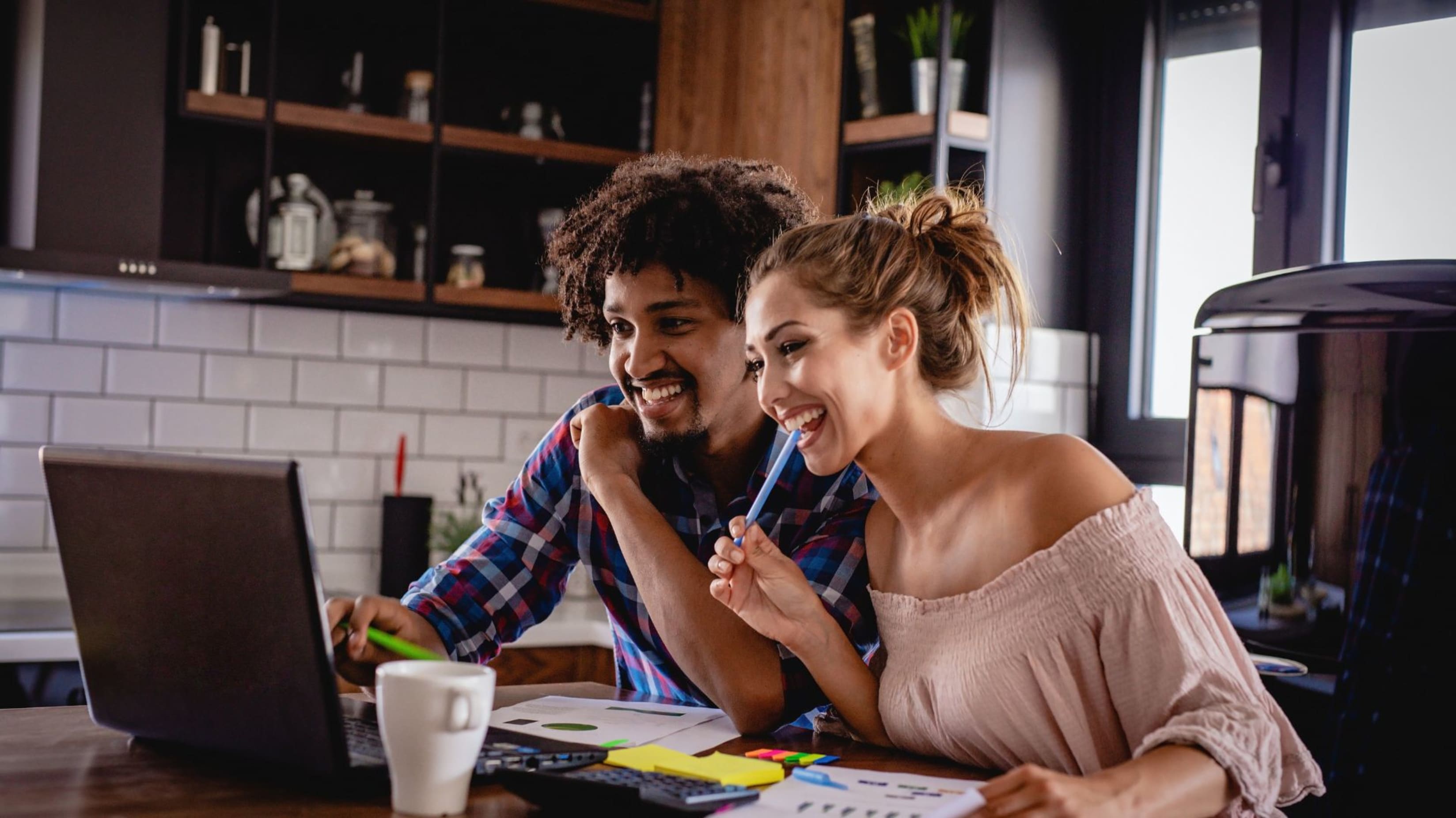 Women and men in the kitchen talking about Key Factors Affecting Your Home Buying Budget