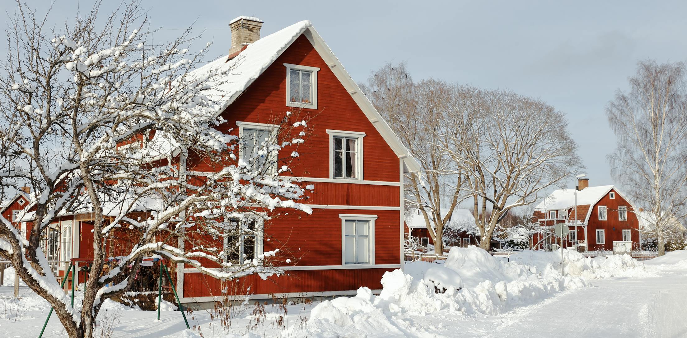 Two red houses covered in snow