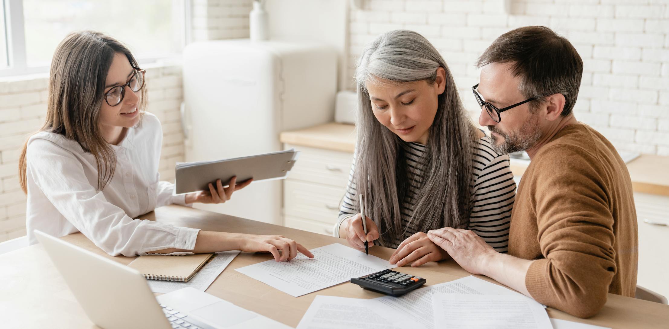 Real estate agent helping couple sign papers and buy a home
