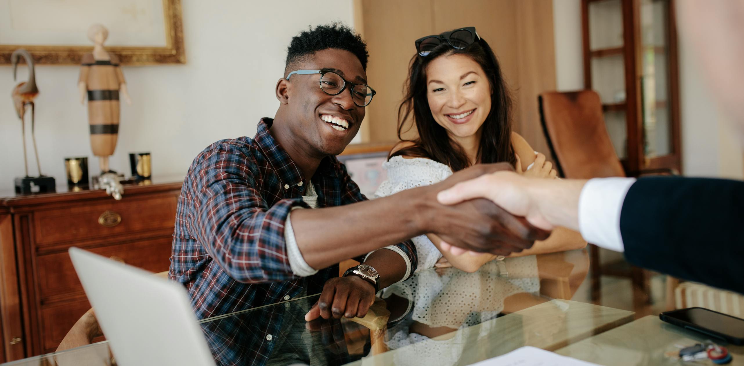 New homeowners shaking hands with their real estate agent