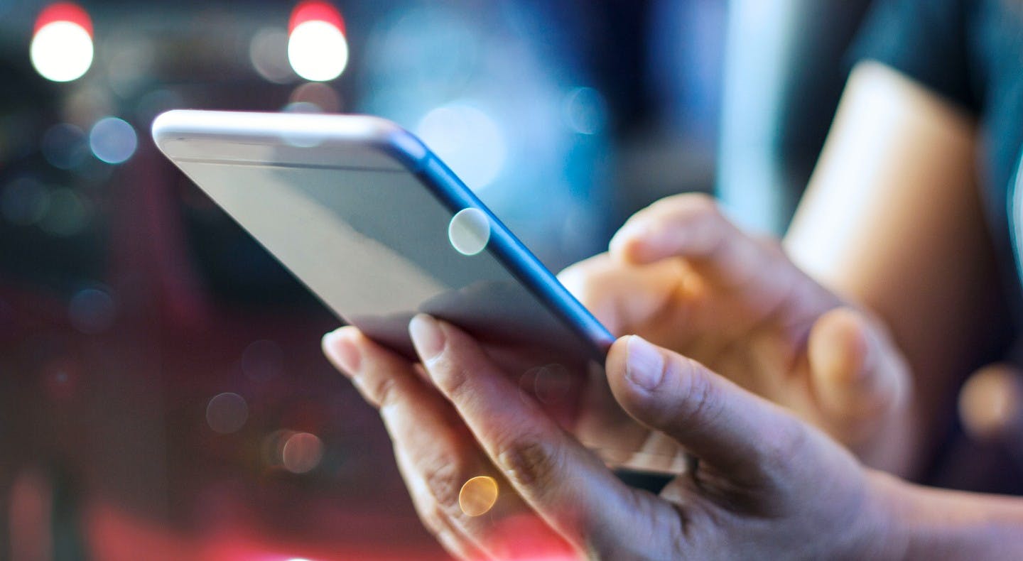 A hand holds a cell phone