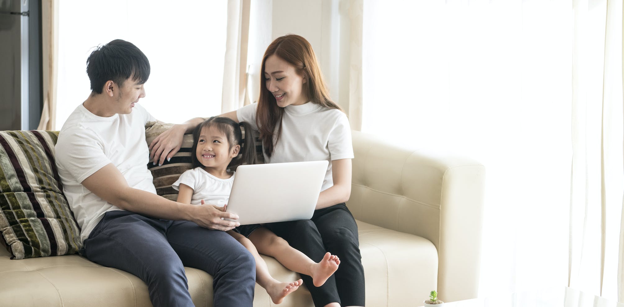 Family using a computer on a sofa