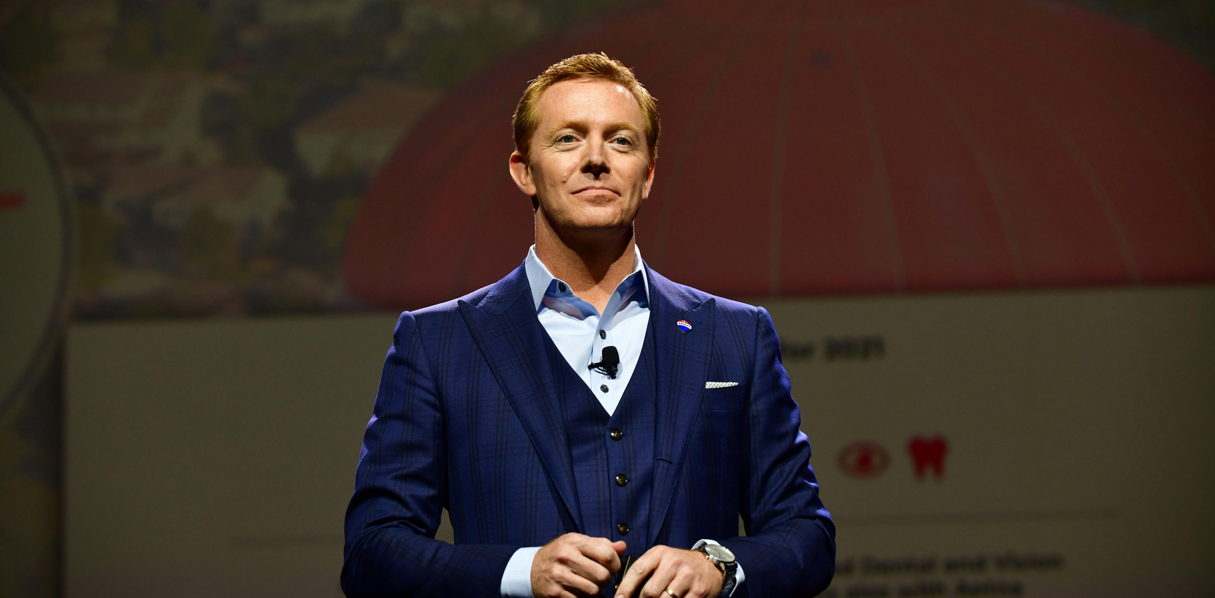Nick Bailey stands on stage at the 2021 RE/MAX R4 convention
