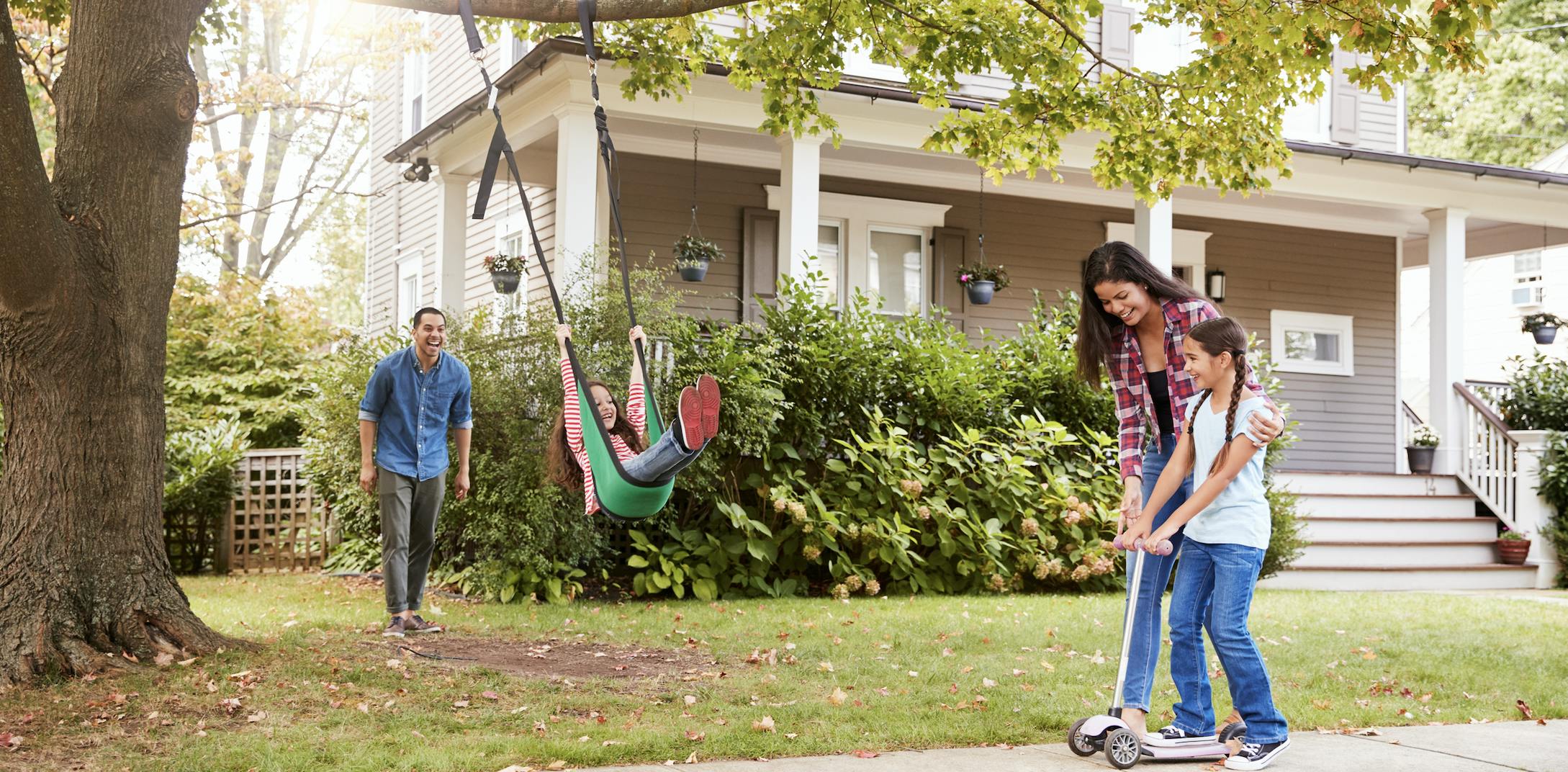 Family plays in the front yard of their house.