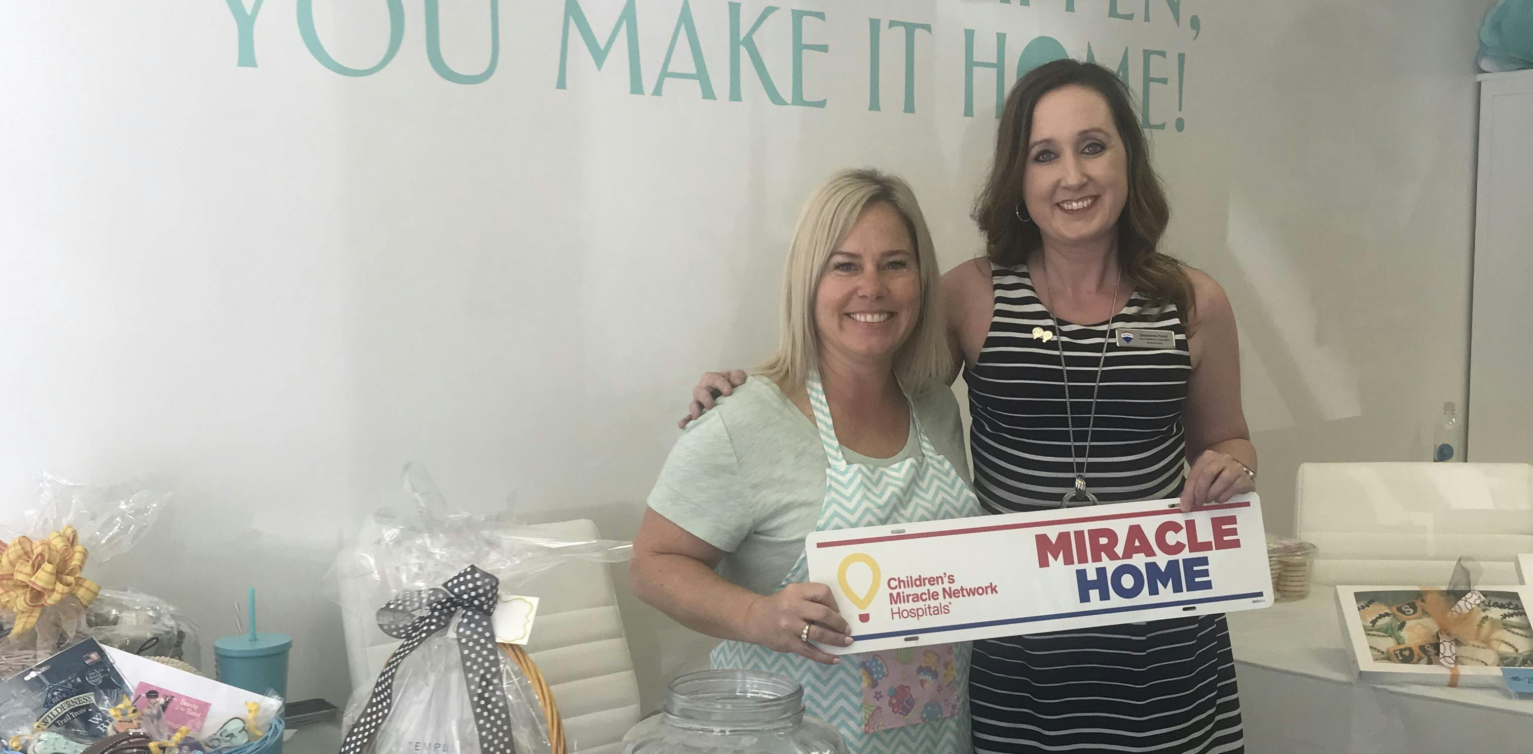 Affiliates from RE/MAX Gold hold a Miracle Home sign rider