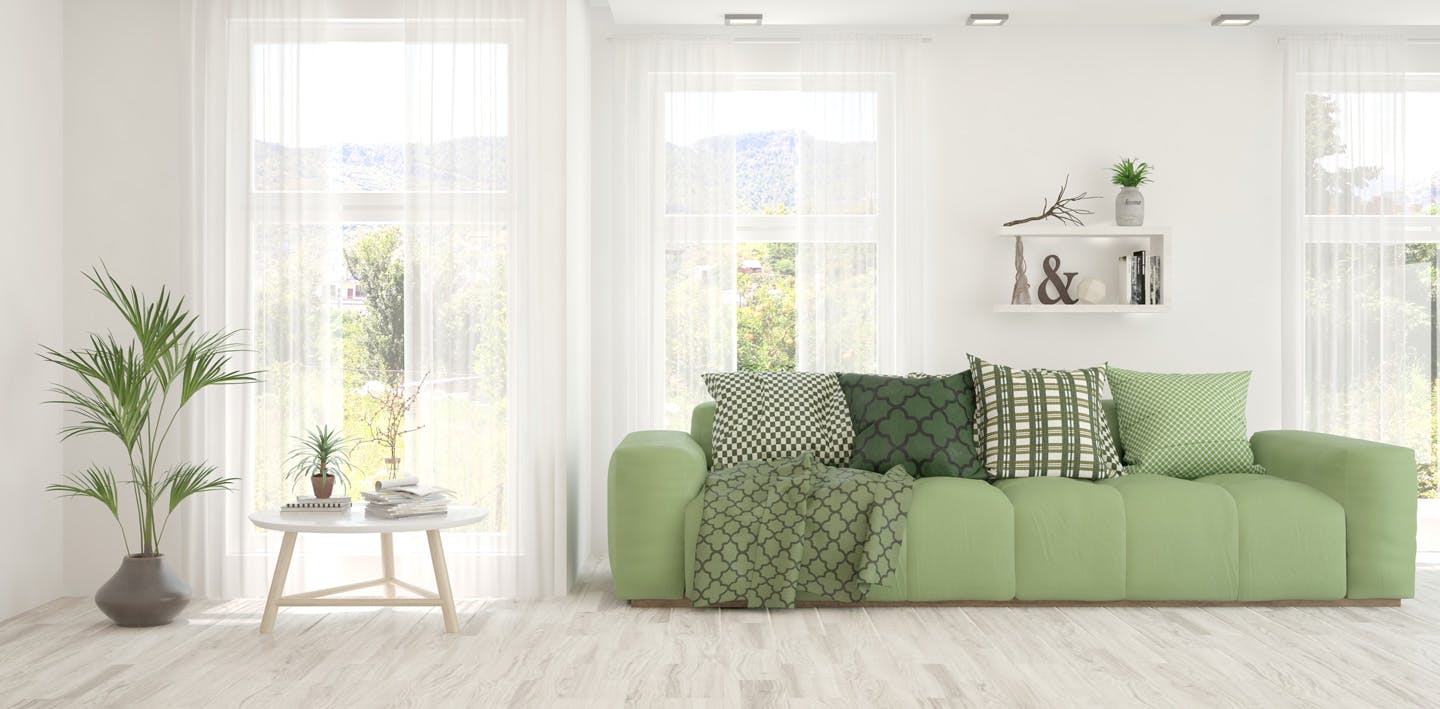 A living room with white walls and a pale green couch.
