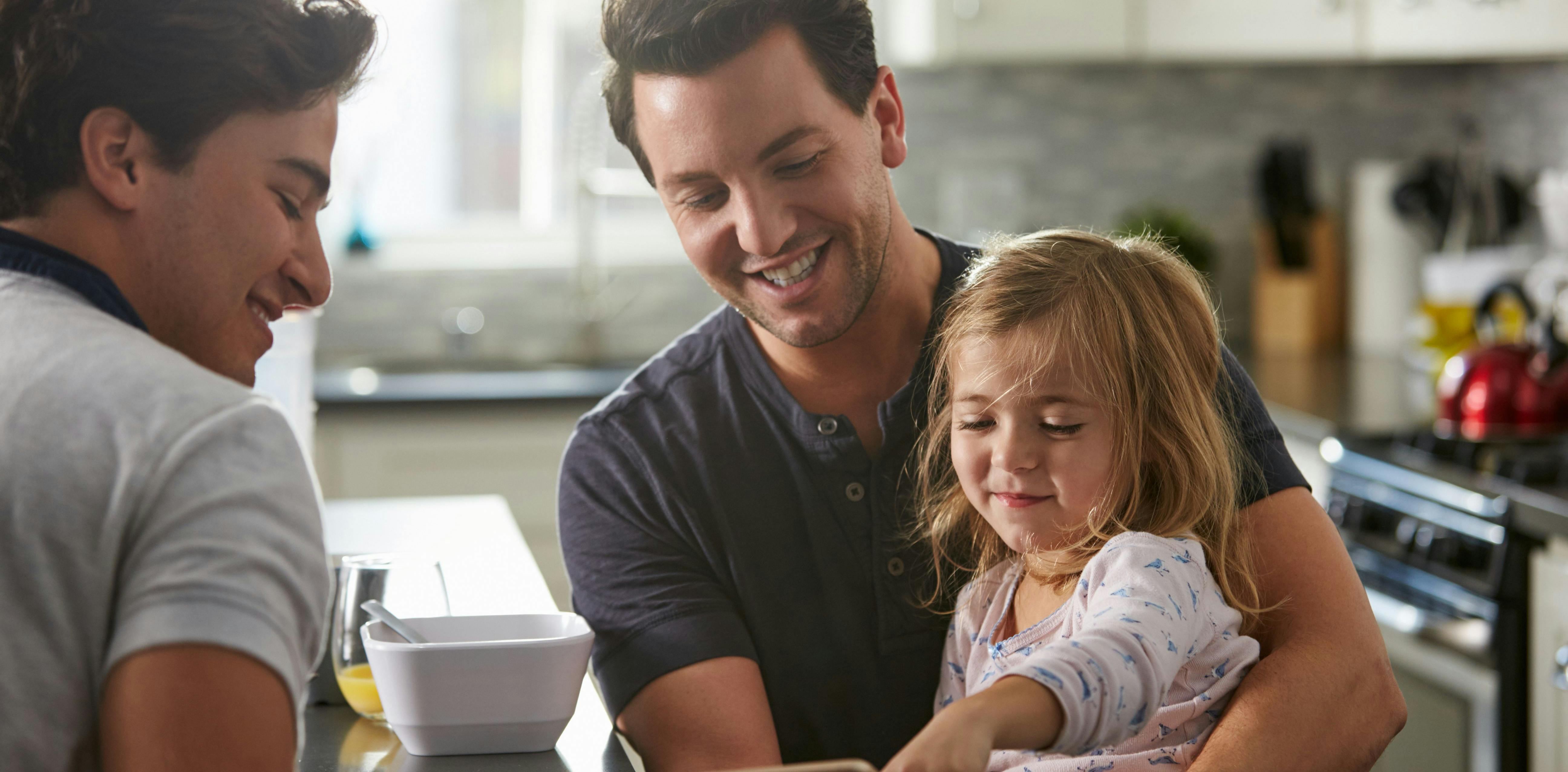 Two men with a child in the kitchen