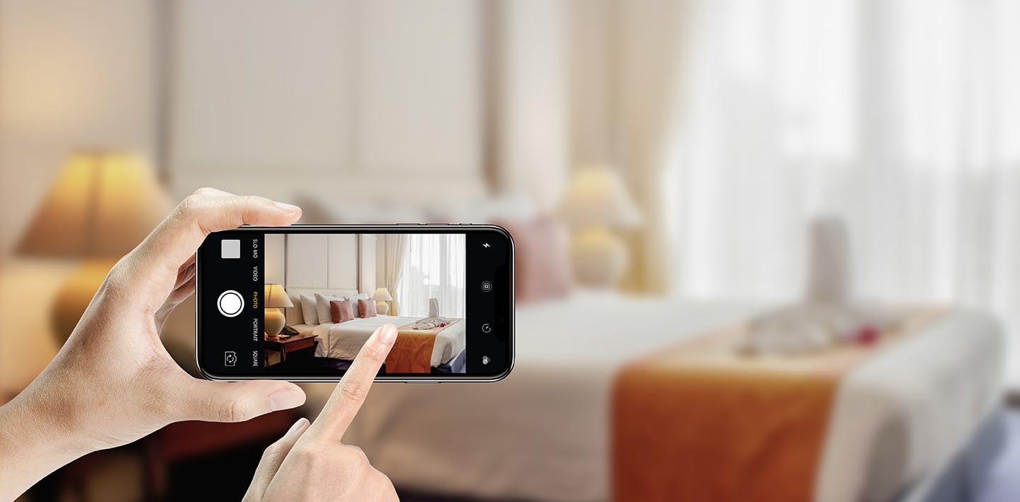 Real estate agent takes photo of a bedroom with an iPhone