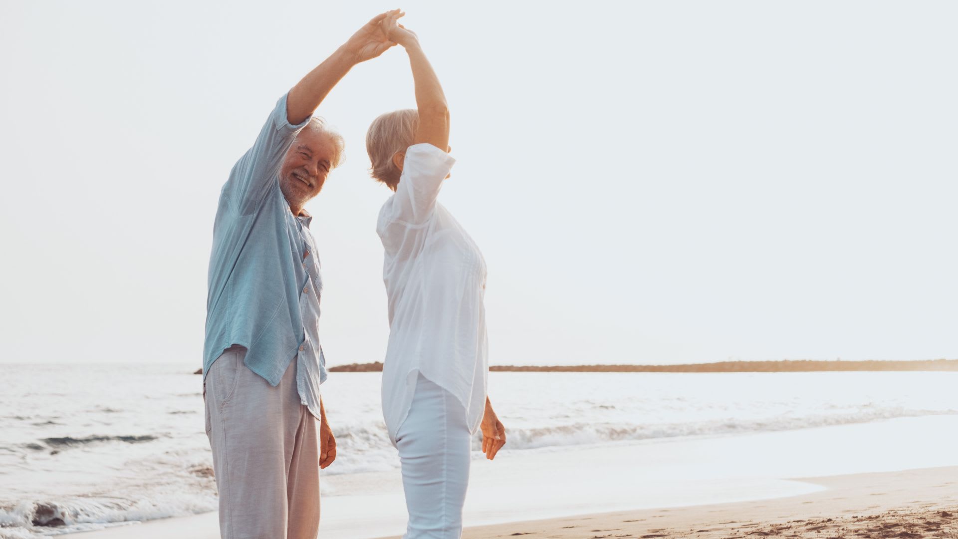 a couple on the beach talking about Why Canadian Snowbirds Are Selling Their US Homes