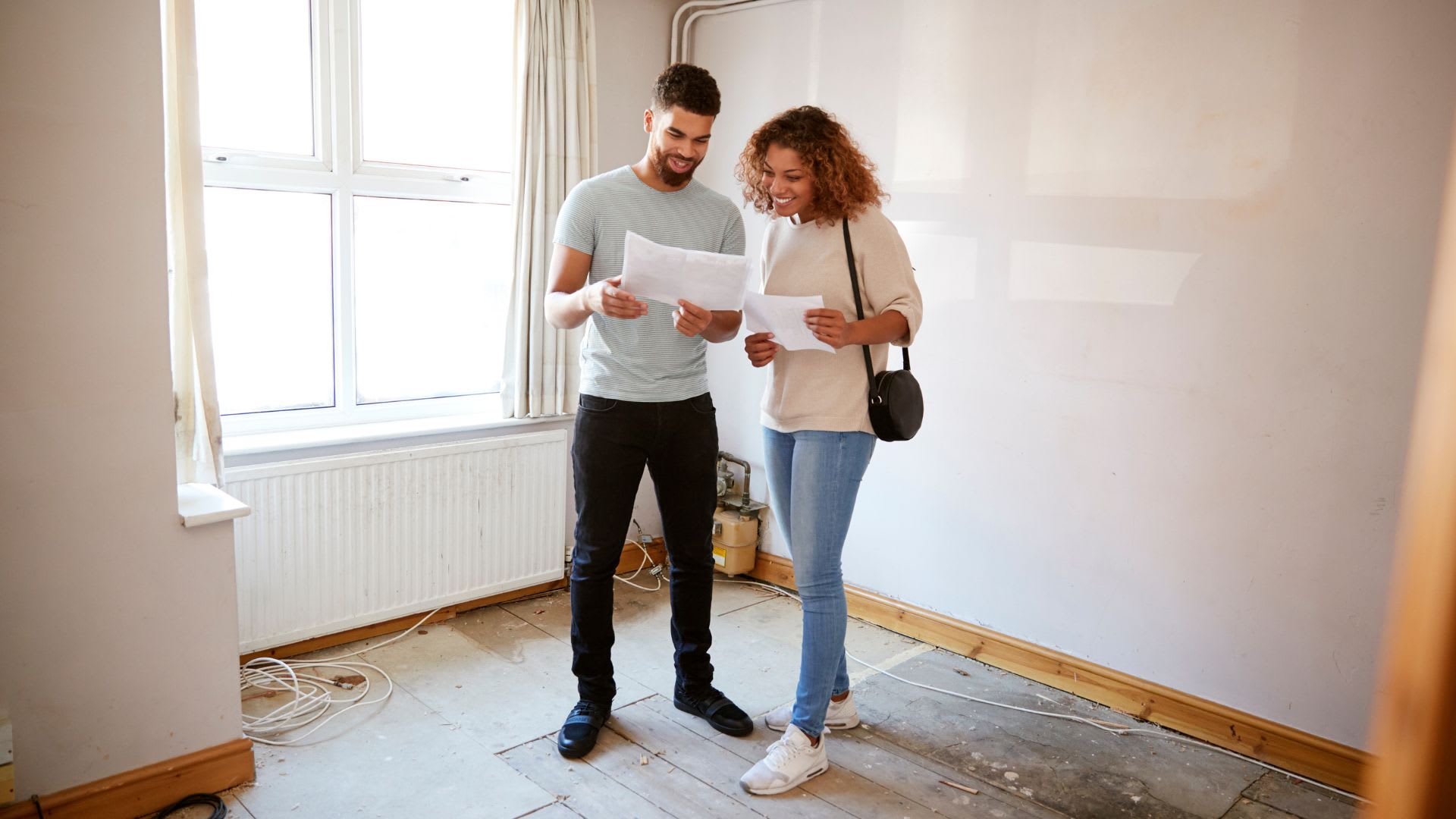 A couple in their new build house looking a documents talking about Federal First-Time Homebuyer Incentives