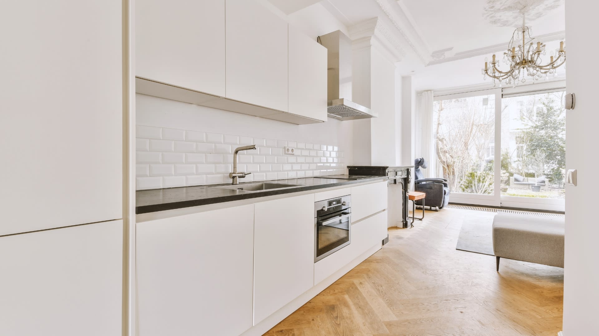 Fully renovated kitchen with built-in oven and modern finishes, flowing into a bright living room, illustrating a turnkey home ready for its next owner.