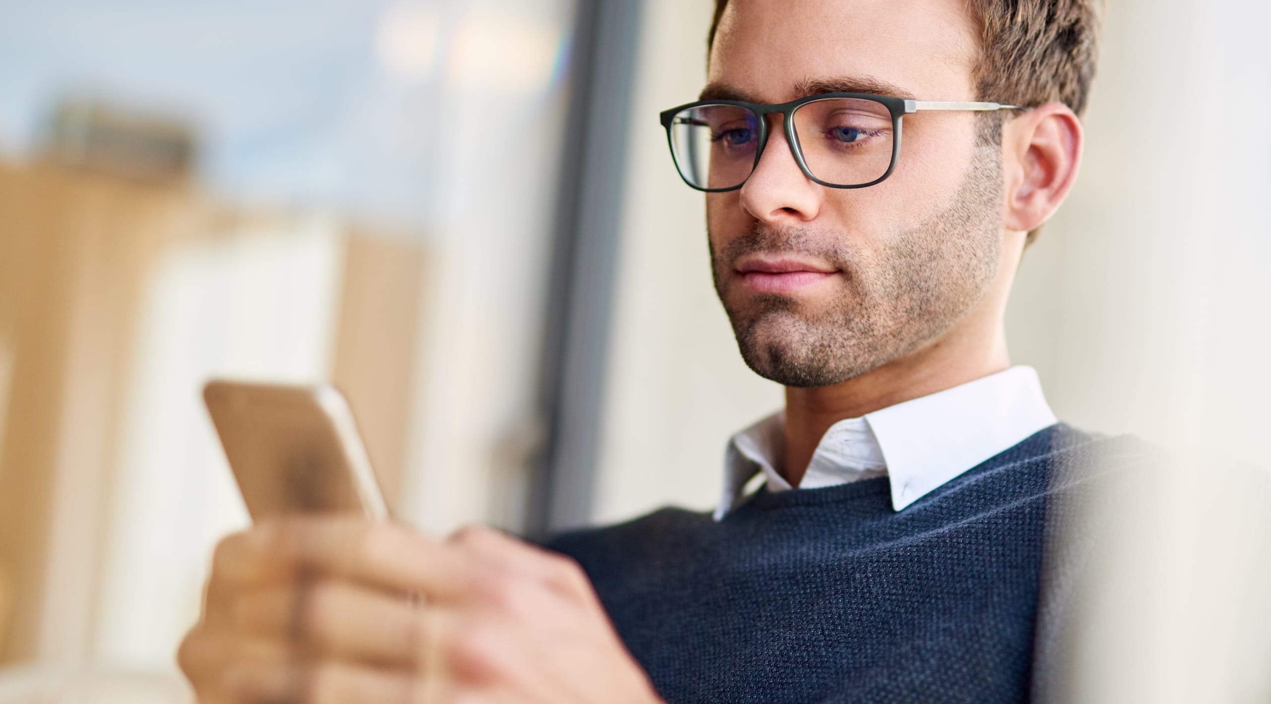 Young businessman sending a text while working in his office man