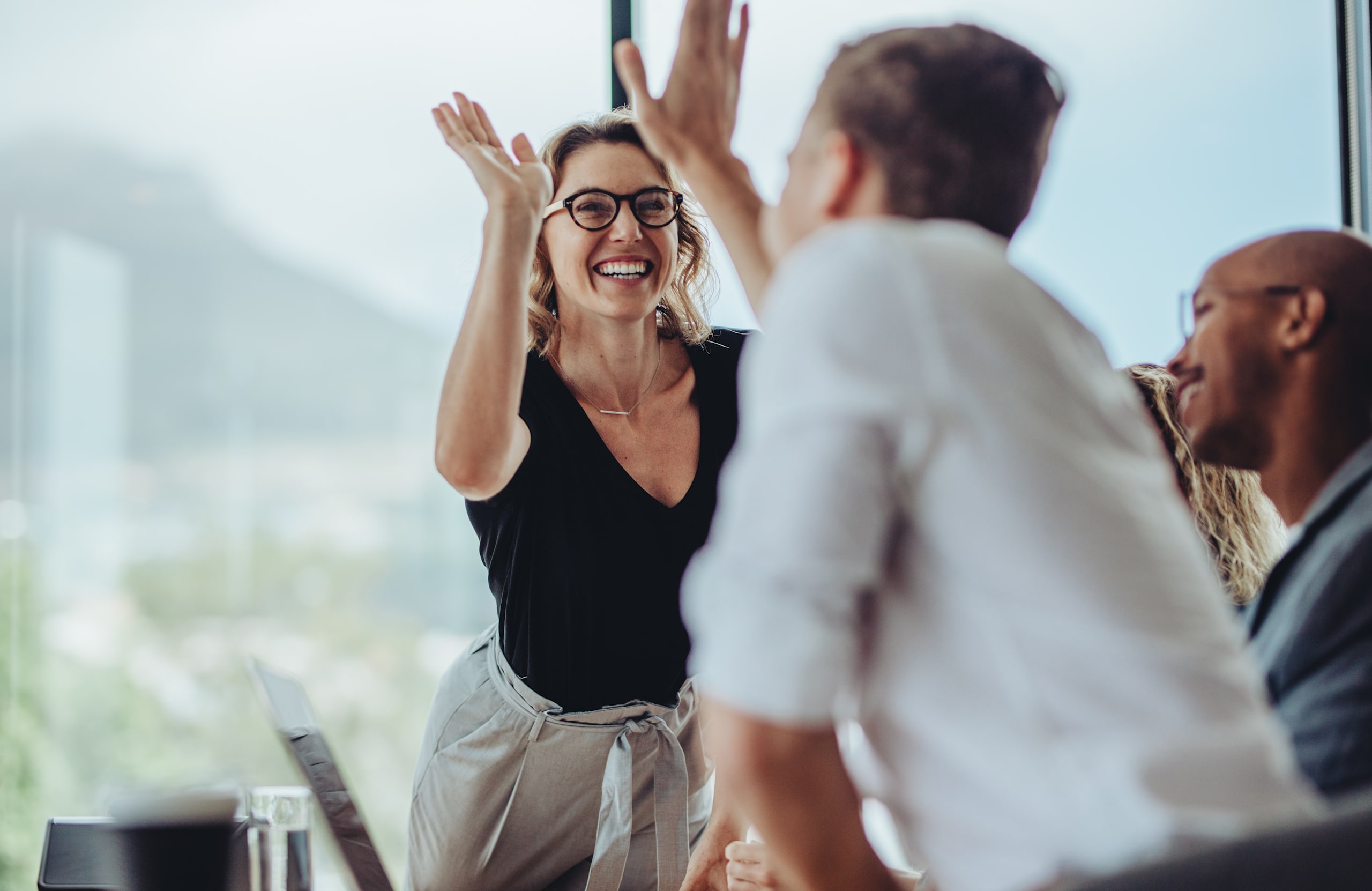 Businesswoman,Giving,A,High,Five,To,Male,Colleague,In,Meeting.