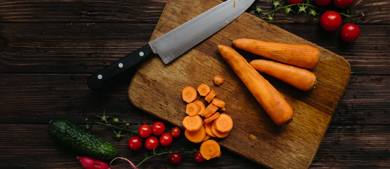 As assortment of kitchen knives flat laid on a neutral background