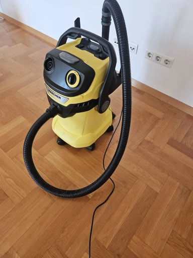 A yellow and black vacuum on a wooden floor