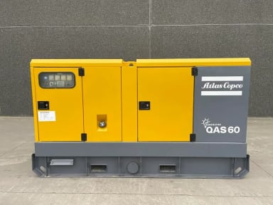 A yellow and gray machine sitting on top of a cement floor