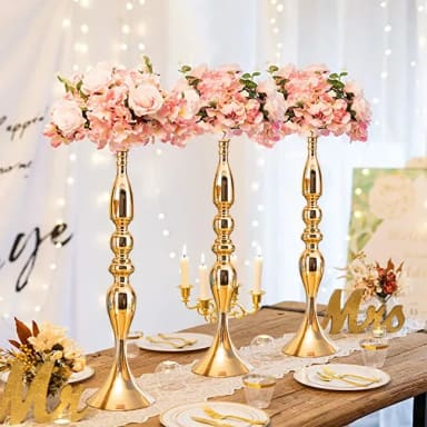 A table topped with gold candlesticks and pink flowers