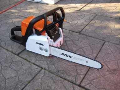 A chainsaw is laying on the ground