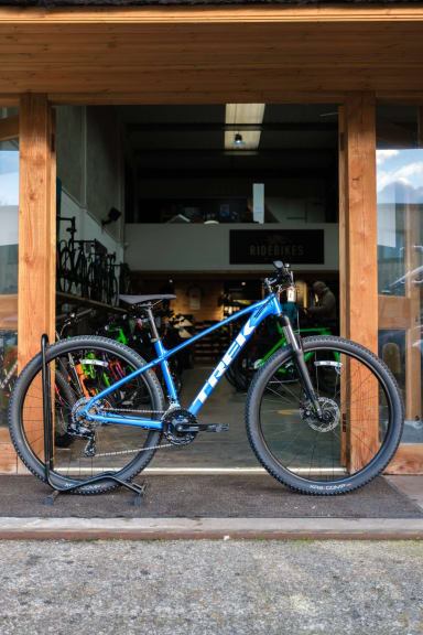 A blue bike parked in front of a store