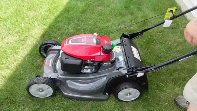 A man is cutting the grass with a lawn mower