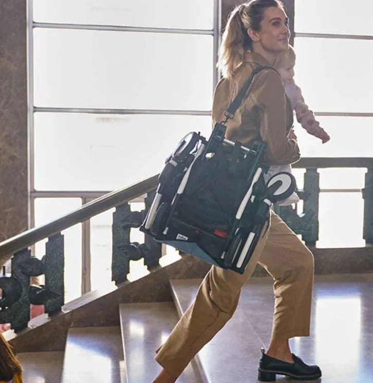 A woman carrying a black bag down a flight of stairs