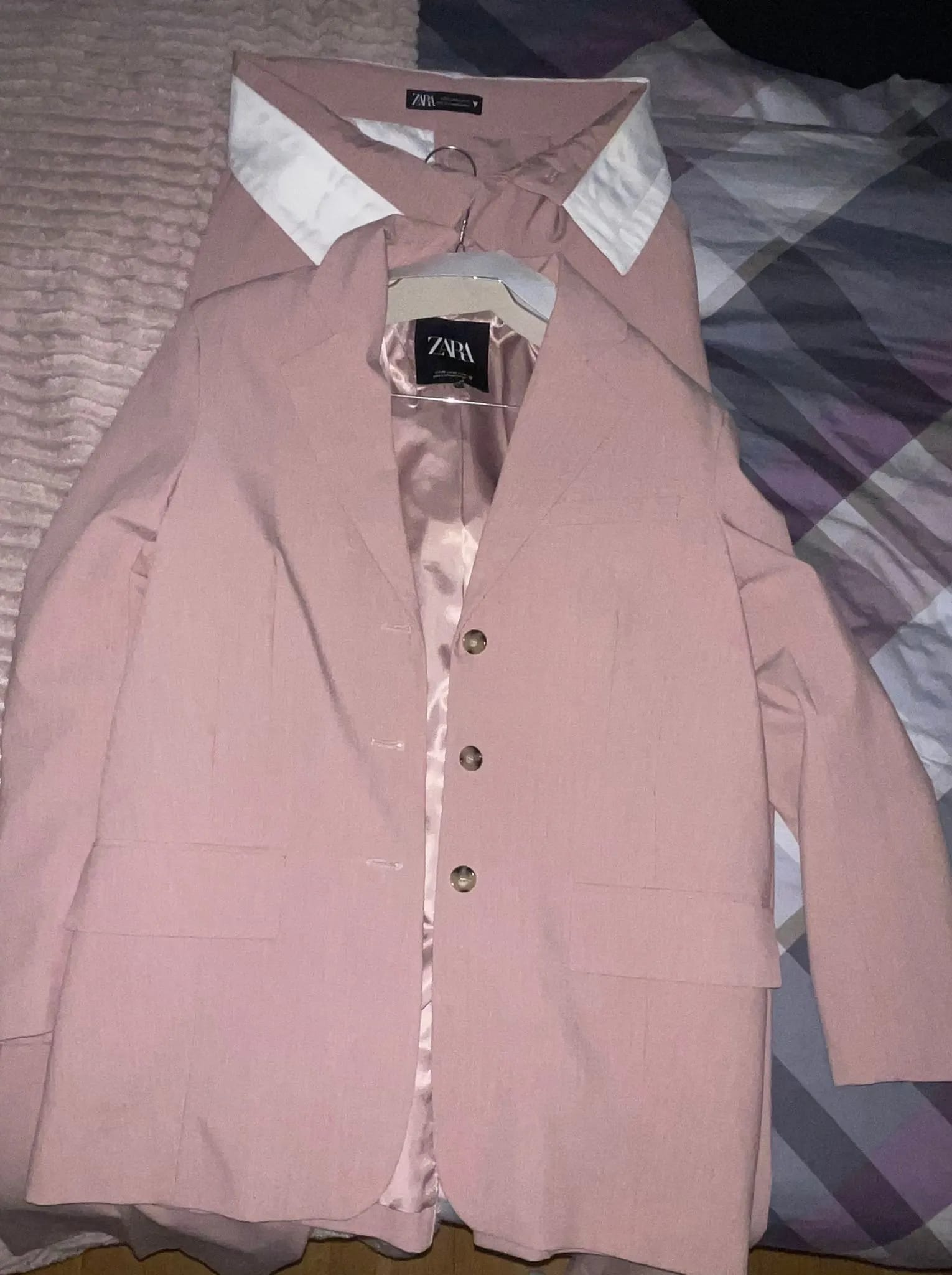 A pink jacket with a white shirt underneath it