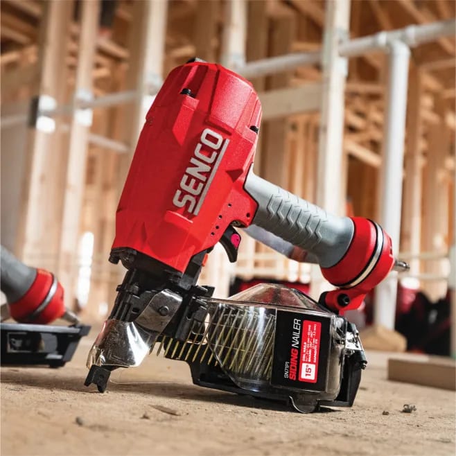 A red cordless driller laying on the ground