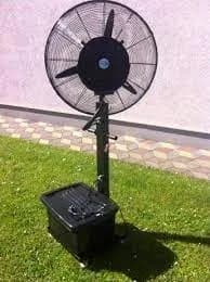 A black fan sitting on top of a green field