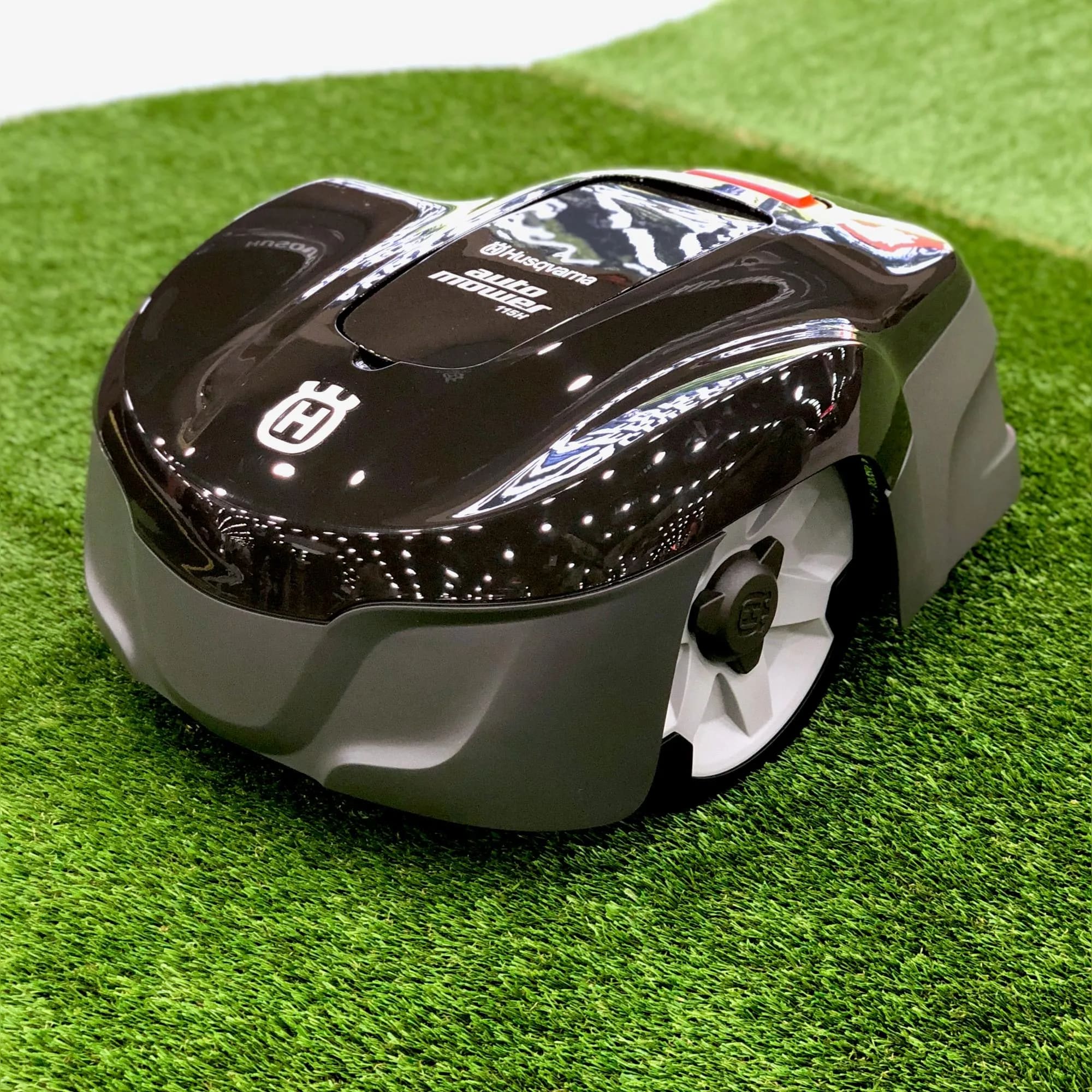 A robotic lawn mower sitting on top of a green field