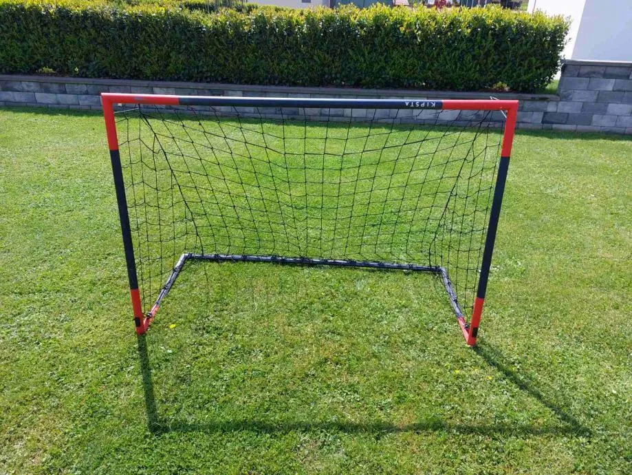 A soccer goal in the middle of a grassy field