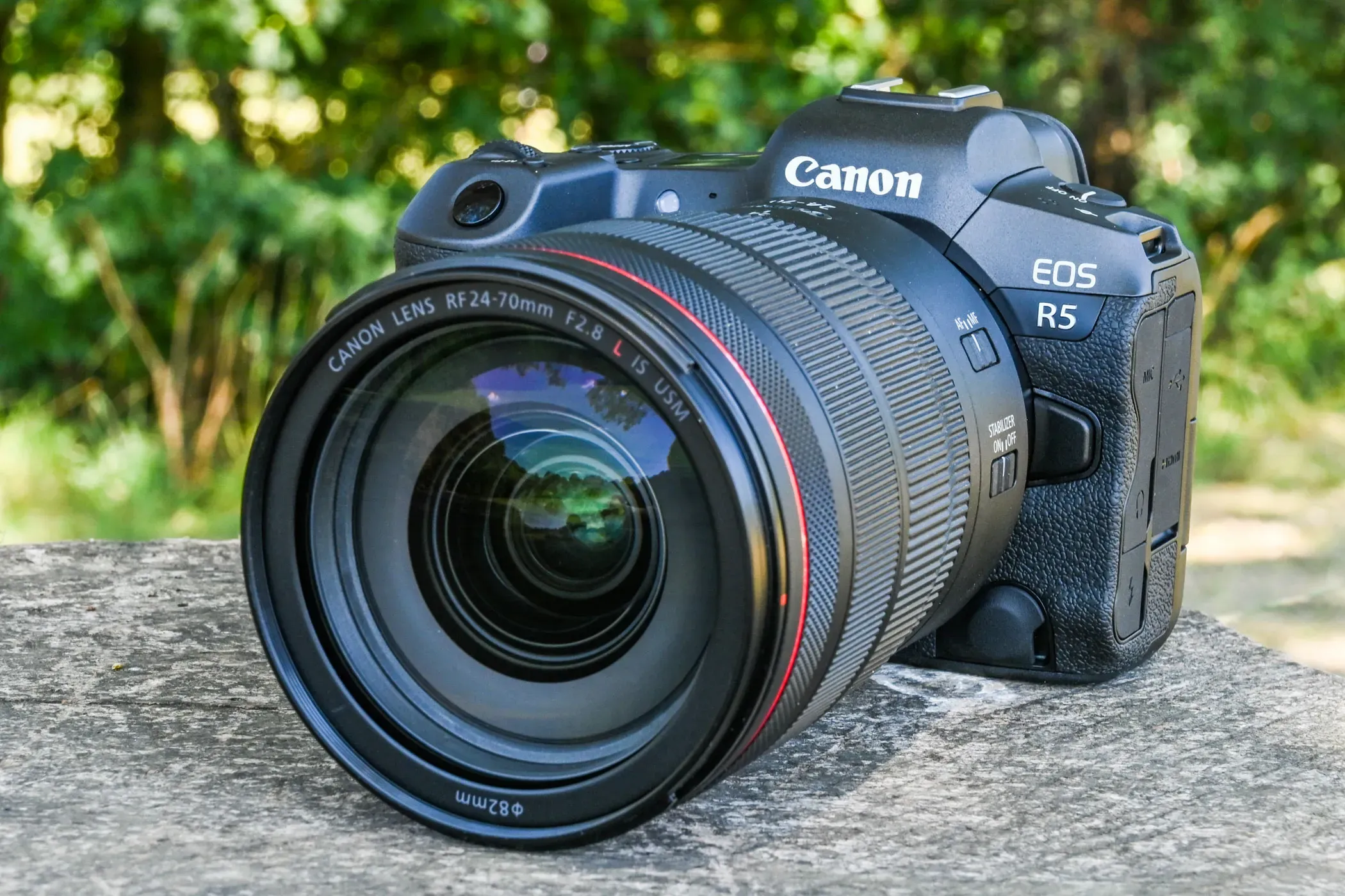A canon camera sitting on top of a rock