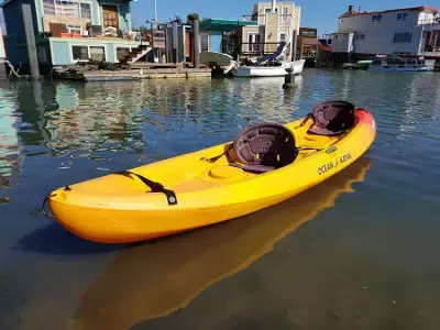 A yellow kayak sitting in the water next to a dock
