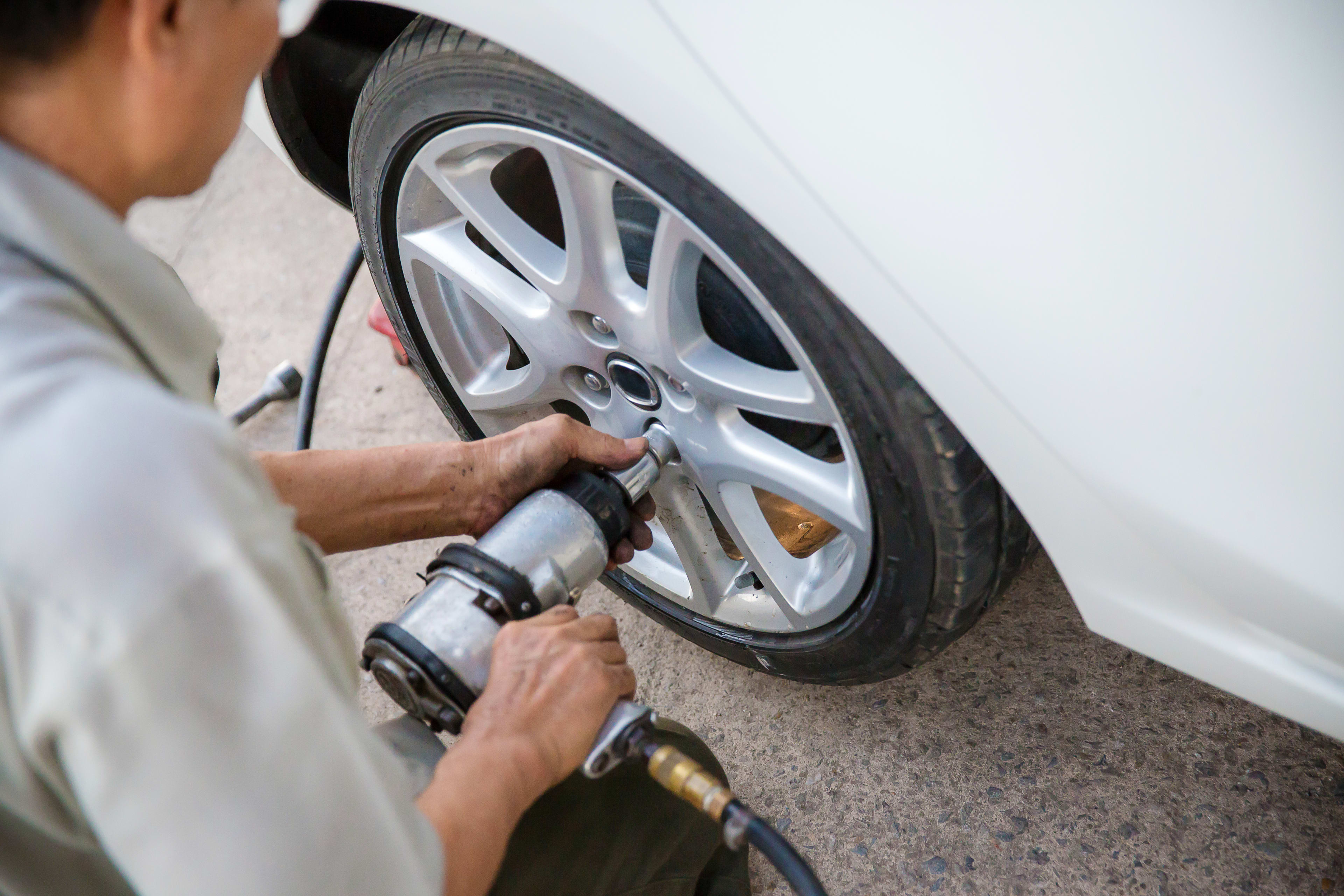 Technician using an impact wrench on lug nuts