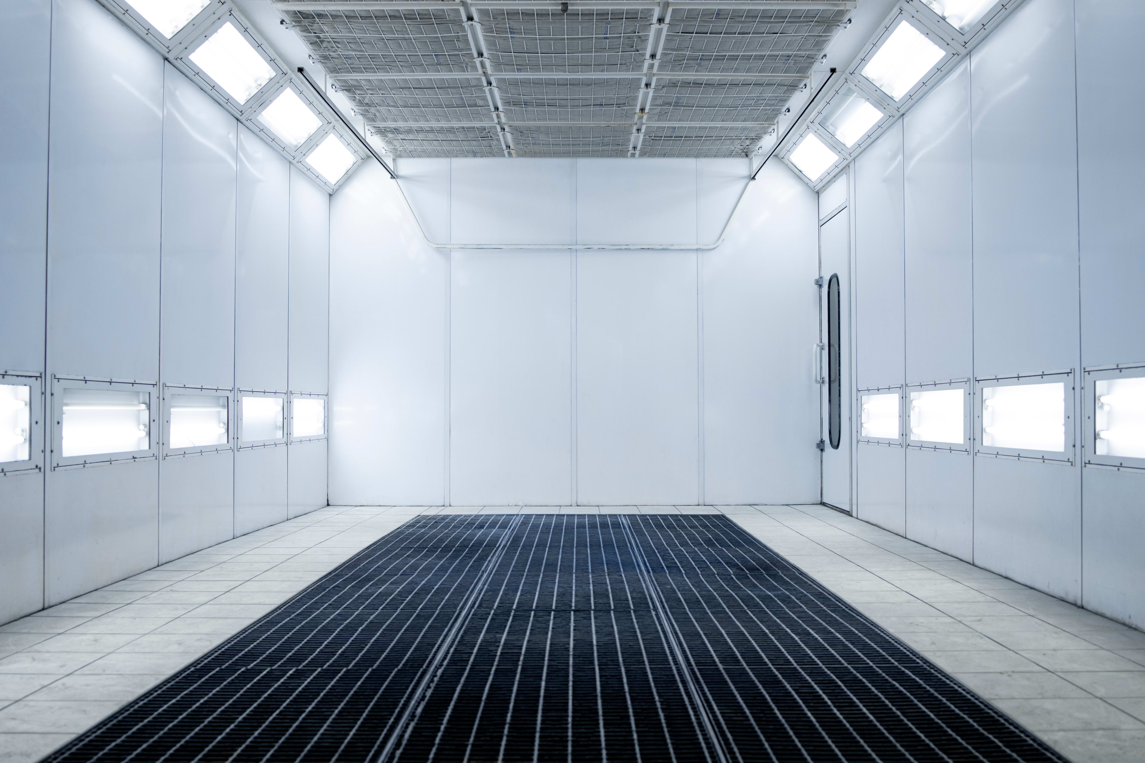 A spray painting booth with a downdraft ventilation system.