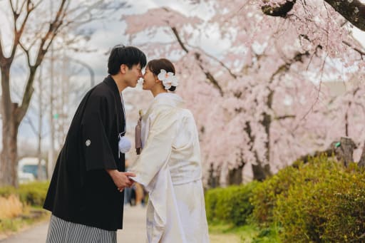 桜が空いっぱいに咲き誇る中、新婦様の白無垢姿は一層際立ち、ロマンチックな一枚に。