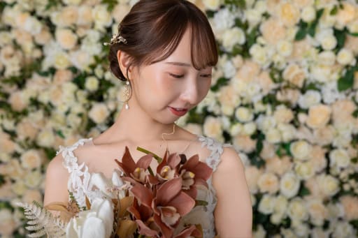 壁一面の薔薇に包まれて、伏し目で魅せる可憐さ