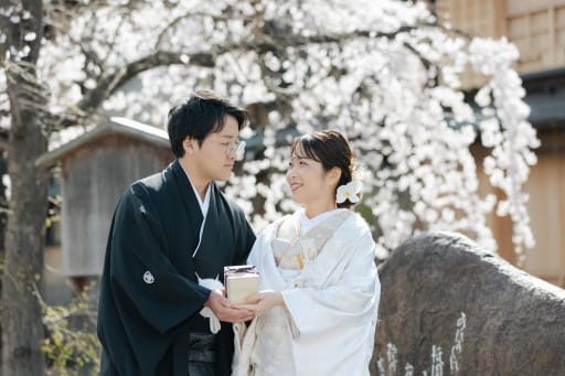  満開の桜を背に寄り添う二人